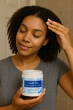 Young woman applying Camille Rose Black Castor Oil + Chebe Buttercream to her natural curly hair for deep moisture and strengthening – ideal for textured hair care in South Africa.